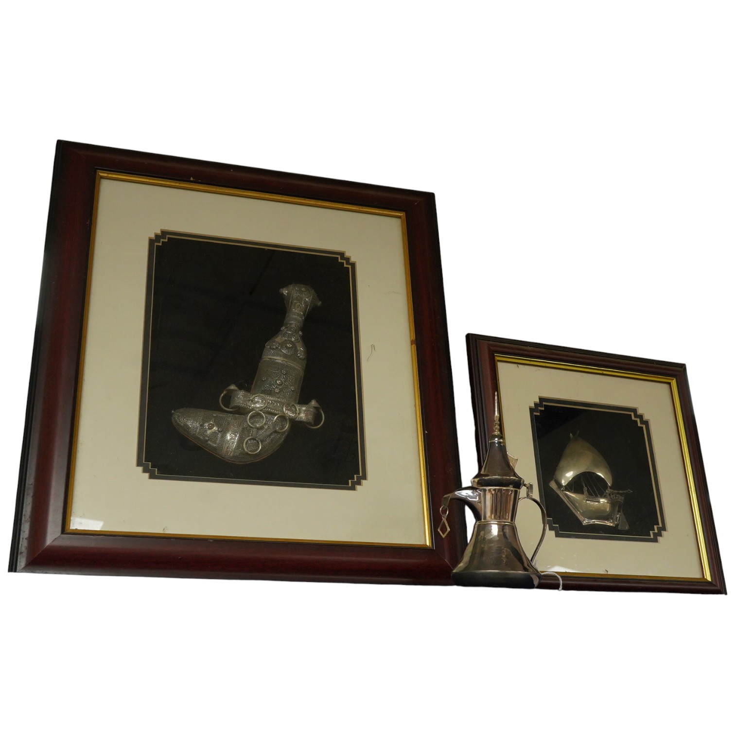 A glass framed white metal khanjar and a similar dhow, together with part model of a Dallah, 16.3cm.